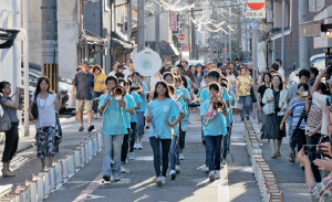 あんどんが並ぶ通りを京都御池中学校のブラスバンド部が行進します